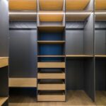 Spacious modern walk-in closet featuring wooden shelving and a sleek design, ideal for organization.